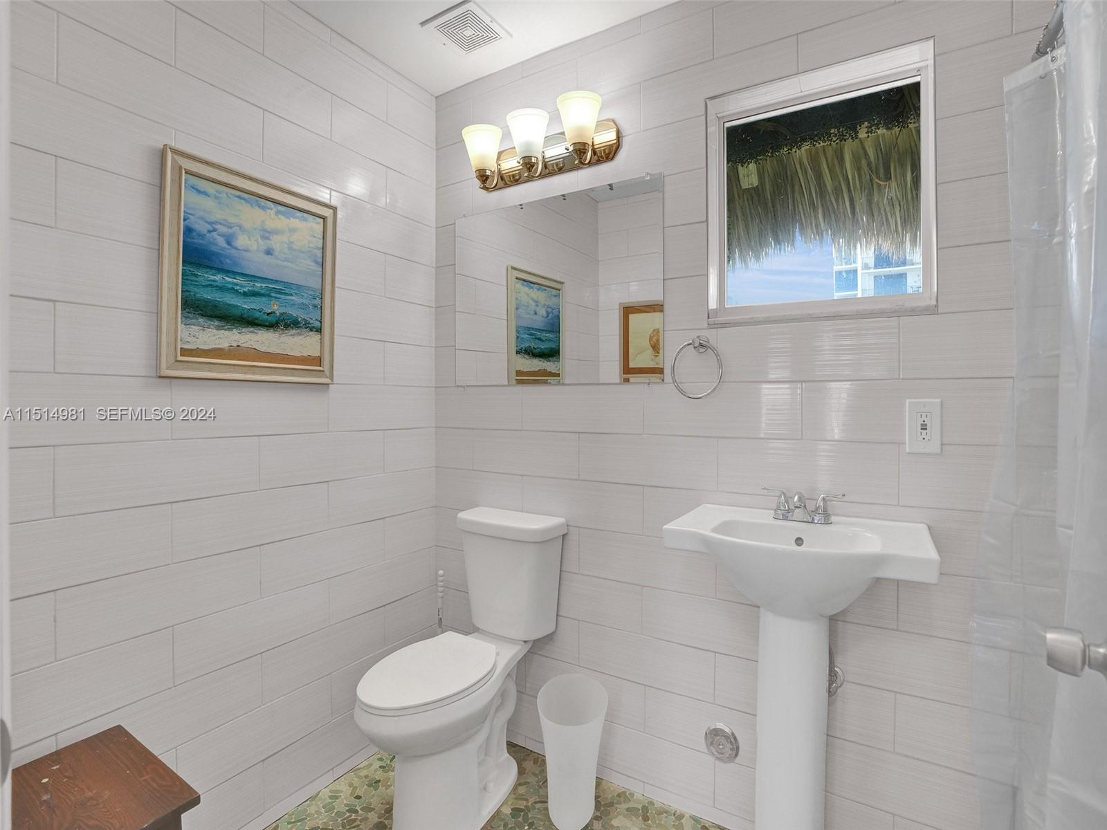 900 North Surf Road, Unit 2 Hollywood, FL 33019 - Photo 16 of 48 a bathroom with a toilet sink and mirror