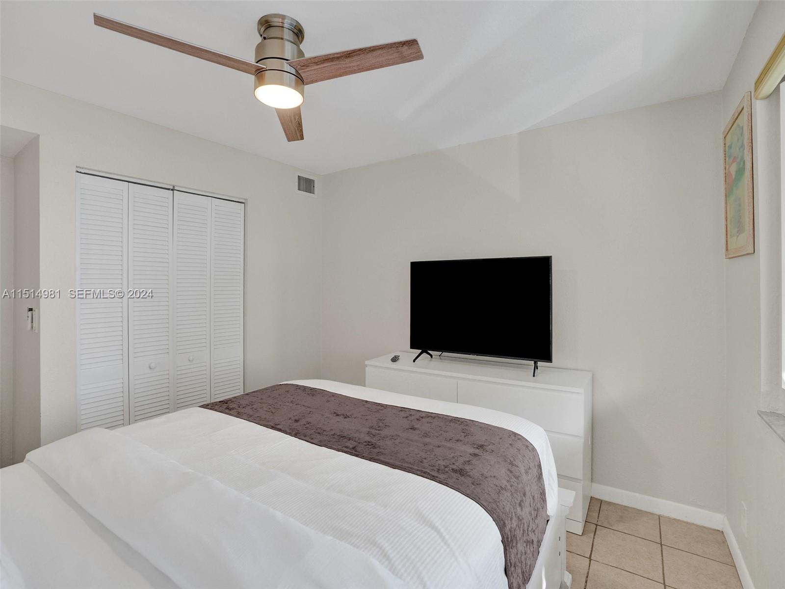 900 North Surf Road, Unit 2 Hollywood, FL 33019 - Photo 21 of 48 a bedroom with a bed and a flat screen tv