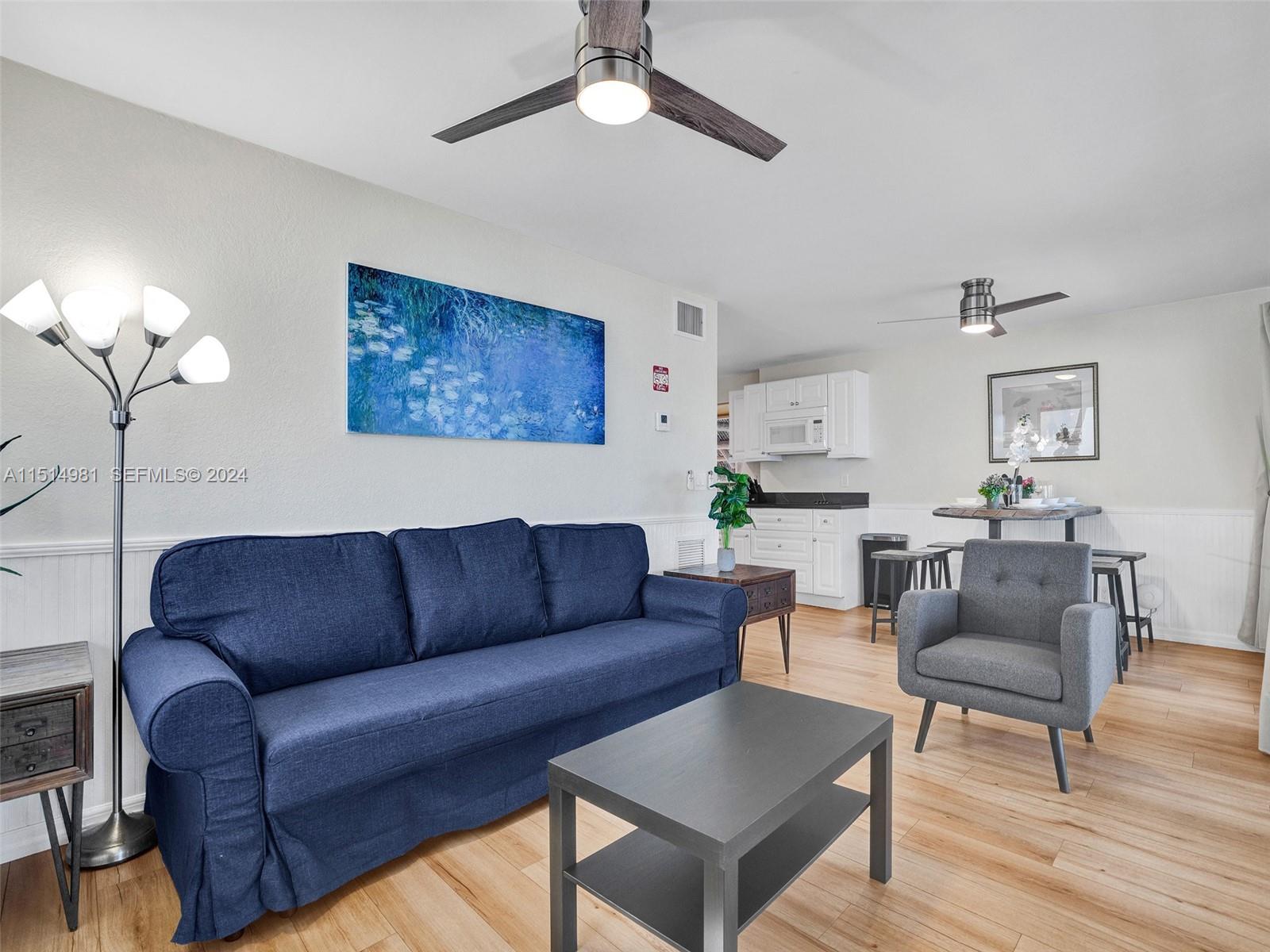 900 North Surf Road, Unit 2 Hollywood, FL 33019 - Photo 24 of 48 a living room with furniture a couch and a chandelier