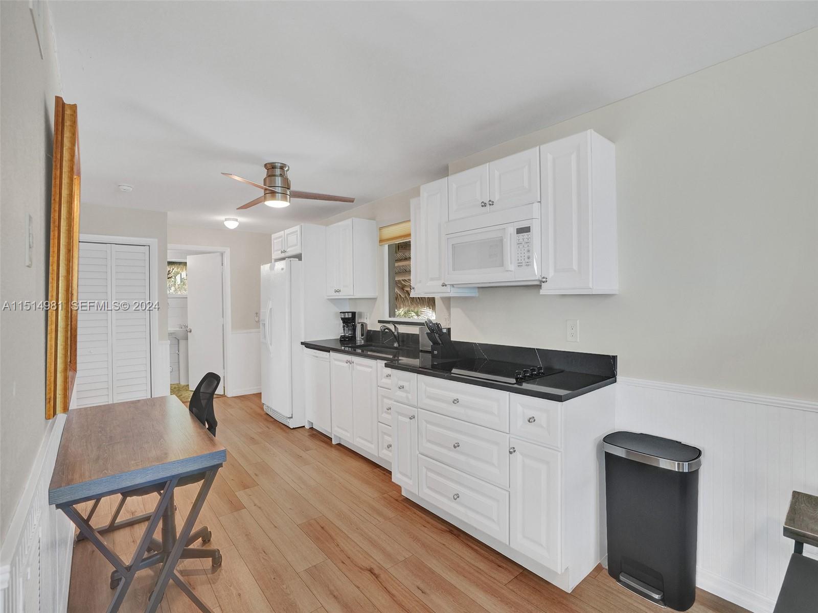 900 North Surf Road, Unit 2 Hollywood, FL 33019 - Photo 7 of 48 a kitchen with granite countertop white cabinets and black appliances