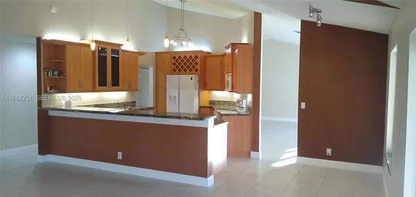 a kitchen with granite countertop a refrigerator and a stove