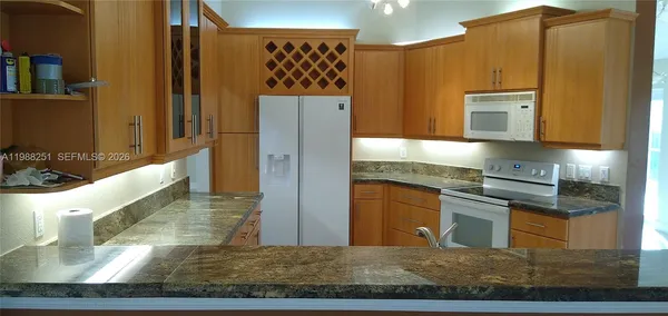 a kitchen with stainless steel appliances granite countertop a refrigerator and a stove