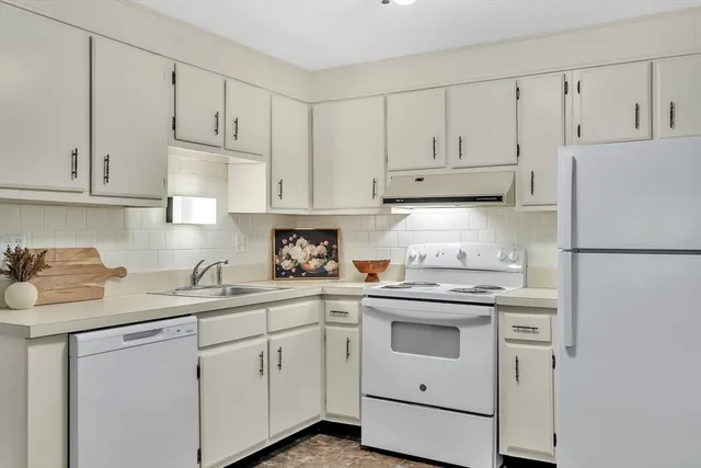 a kitchen with white cabinets and white appliances