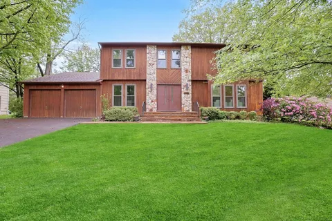 a front view of a house with a yard and trees