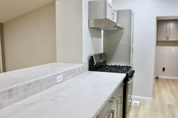 a bedroom with a stove and a white cabinet