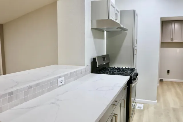 a bedroom with a stove and a white cabinet