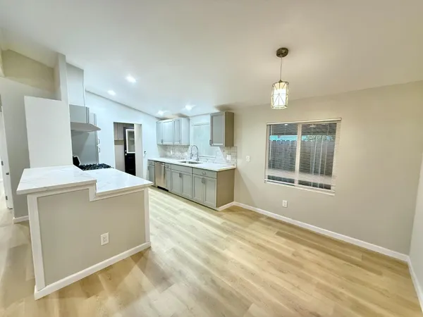 a large kitchen with a stove a refrigerator and a sink