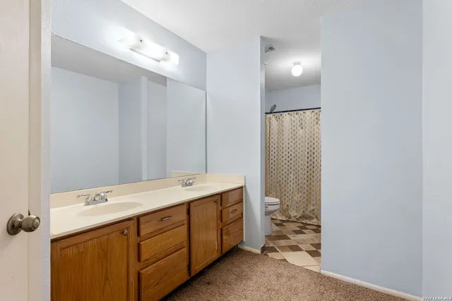 a spacious bathroom with a double vanity sink and a mirror