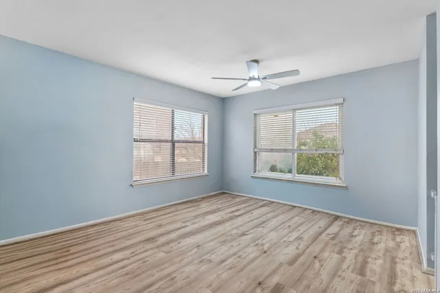 a view of an empty room with a window and a kitchen