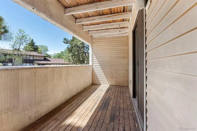a view of a balcony with wooden floor and fence