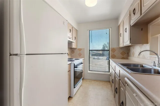 a kitchen with a refrigerator and a sink
