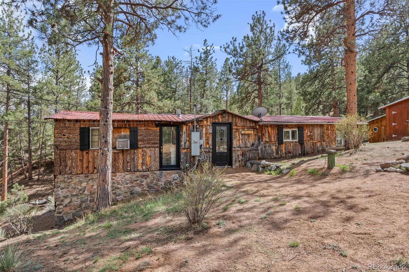 15535 South Elk Creek Road Pine, CO 80470 - Photo 1 of 25 a front view of a house with yard tree and wooden fence