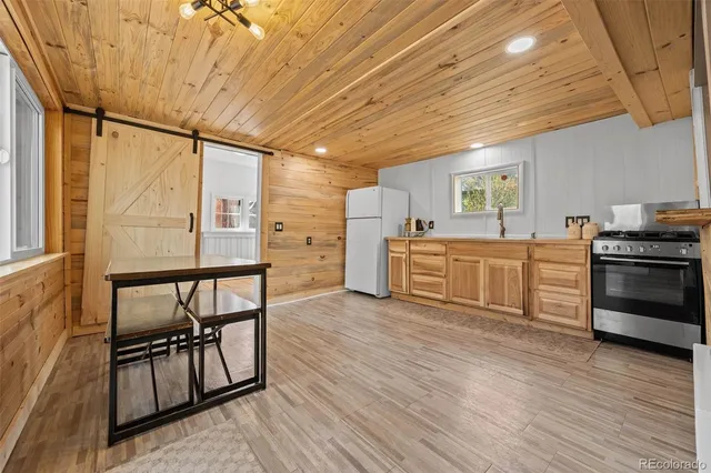 a kitchen with cabinets stainless steel appliances and wooden floor