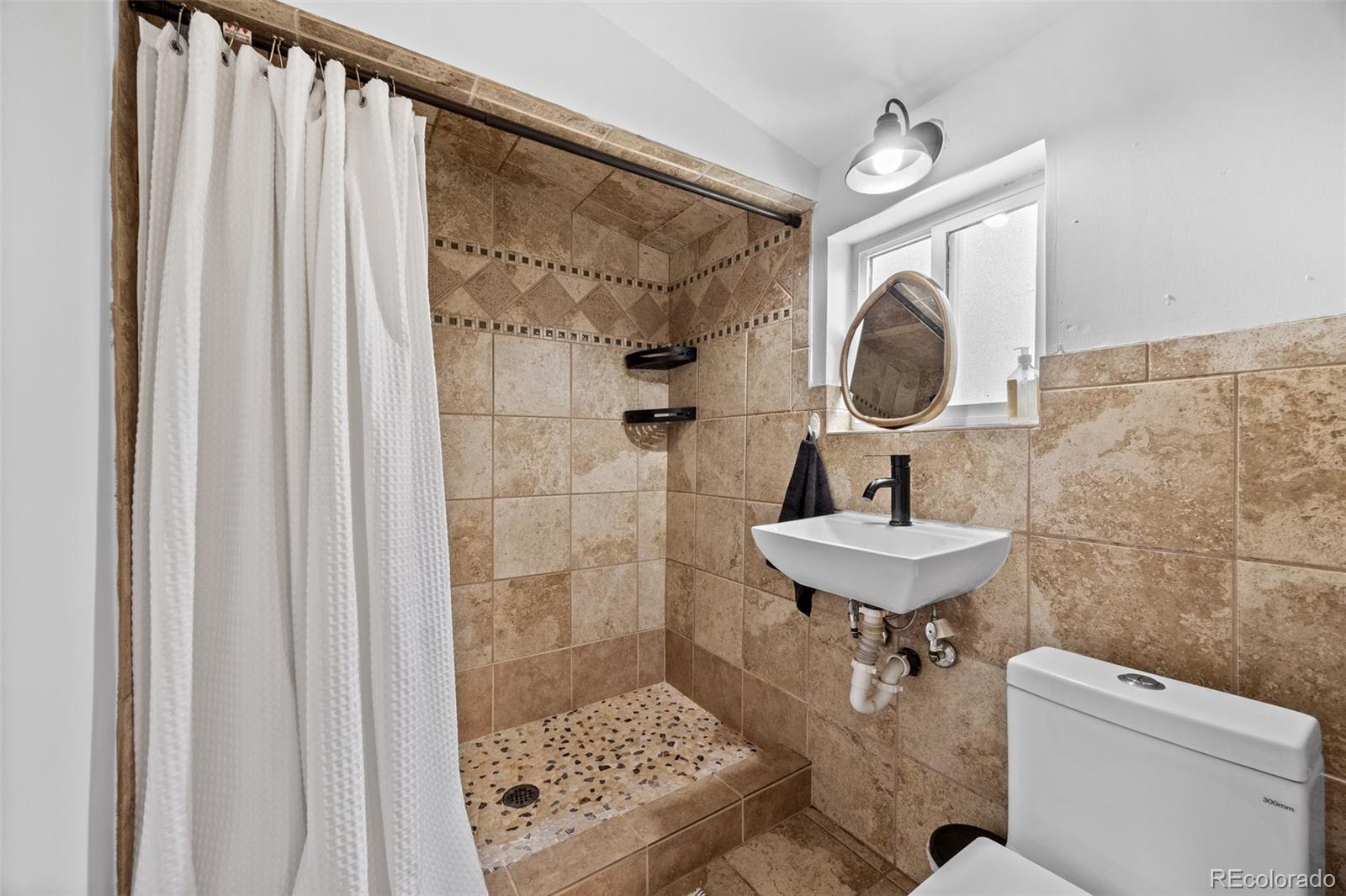 15535 South Elk Creek Road Pine, CO 80470 - Photo 16 of 25 a bathroom with a sink a toilet and shower