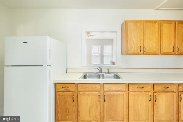 an empty room with wooden floor and fan