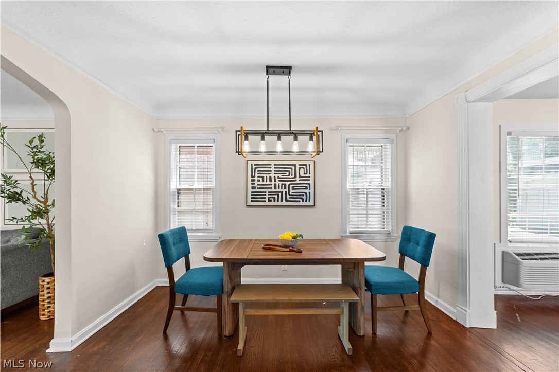 3806 Westwood Road University Heights, OH 44118 - Photo 5 of 41 Dining room featuring wood-finish flooring, a modern linear chandelier, and two double-hung windows with blinds