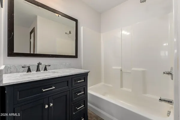 a bathroom with a tub a sink and mirror