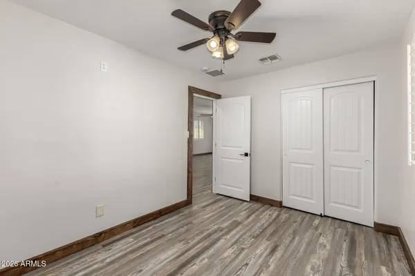 a view of a room with wooden floor and a ceiling fan