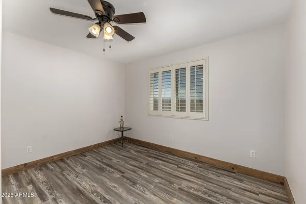 an empty room with a window and a fan