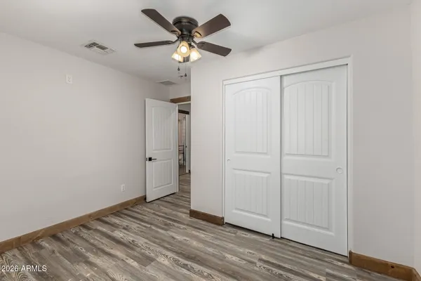 a view of a livingroom with a chandelier fan and wooden floor