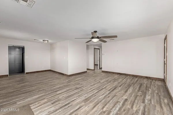 a view of empty room with wooden floor