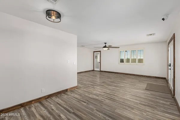 an empty room with wooden floor and windows