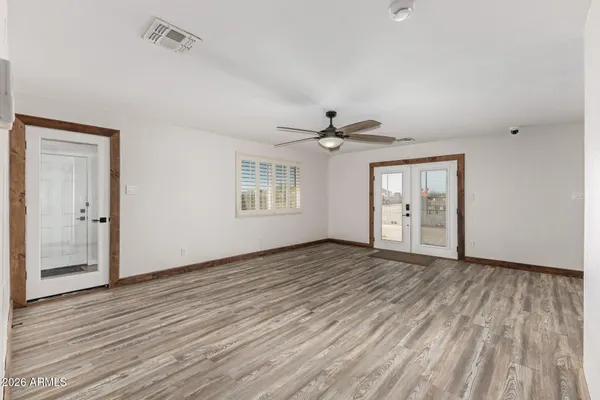 a view of an empty room with wooden floor and a window