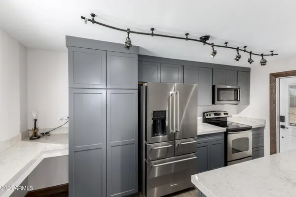 a kitchen with stainless steel appliances a refrigerator and microwave