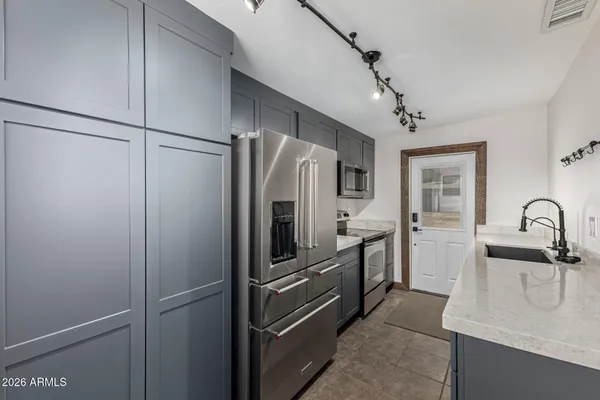 a kitchen with stainless steel appliances granite countertop a refrigerator and a sink