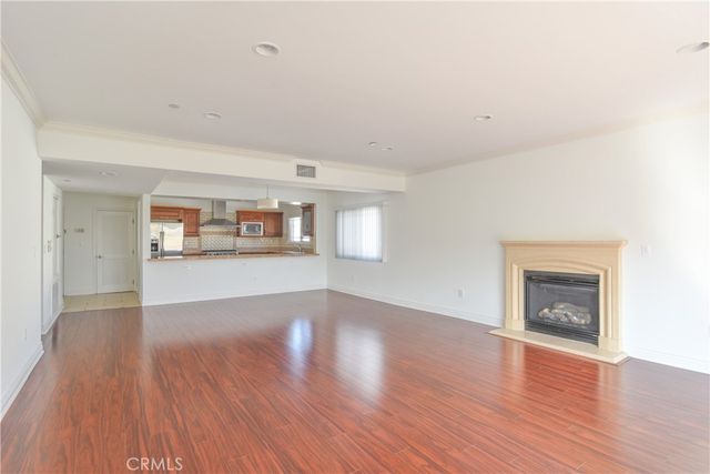 an empty room with wooden floor and a fireplace