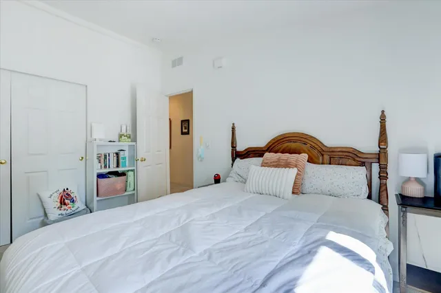 a bedroom with a bed and a lamp on dresser