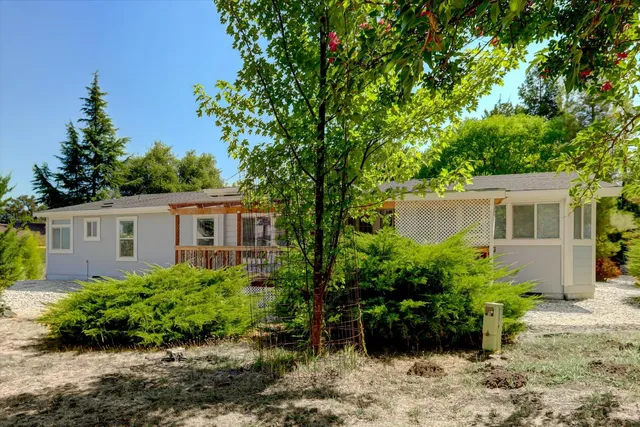a view of a house with a yard and potted plants