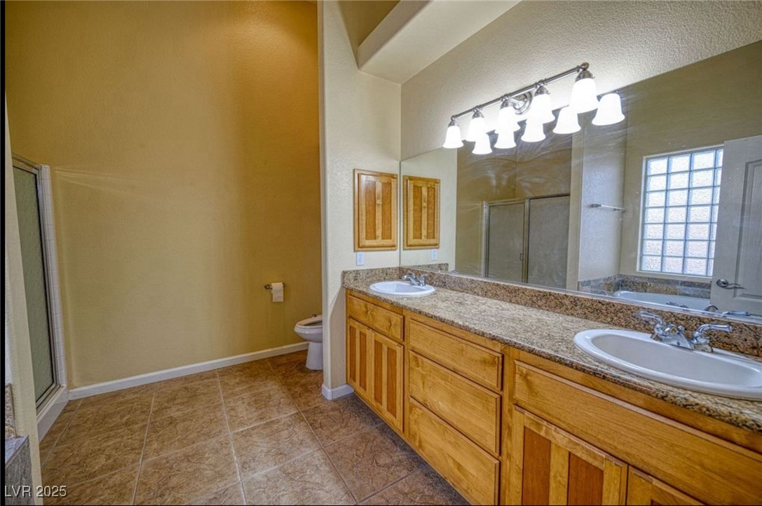 6780 Sandpebble Street Pahrump, NV 89061 - Photo 10 of 25 Bathroom with a shower stall, a garden tub, double vanity, and light tile patterned floors