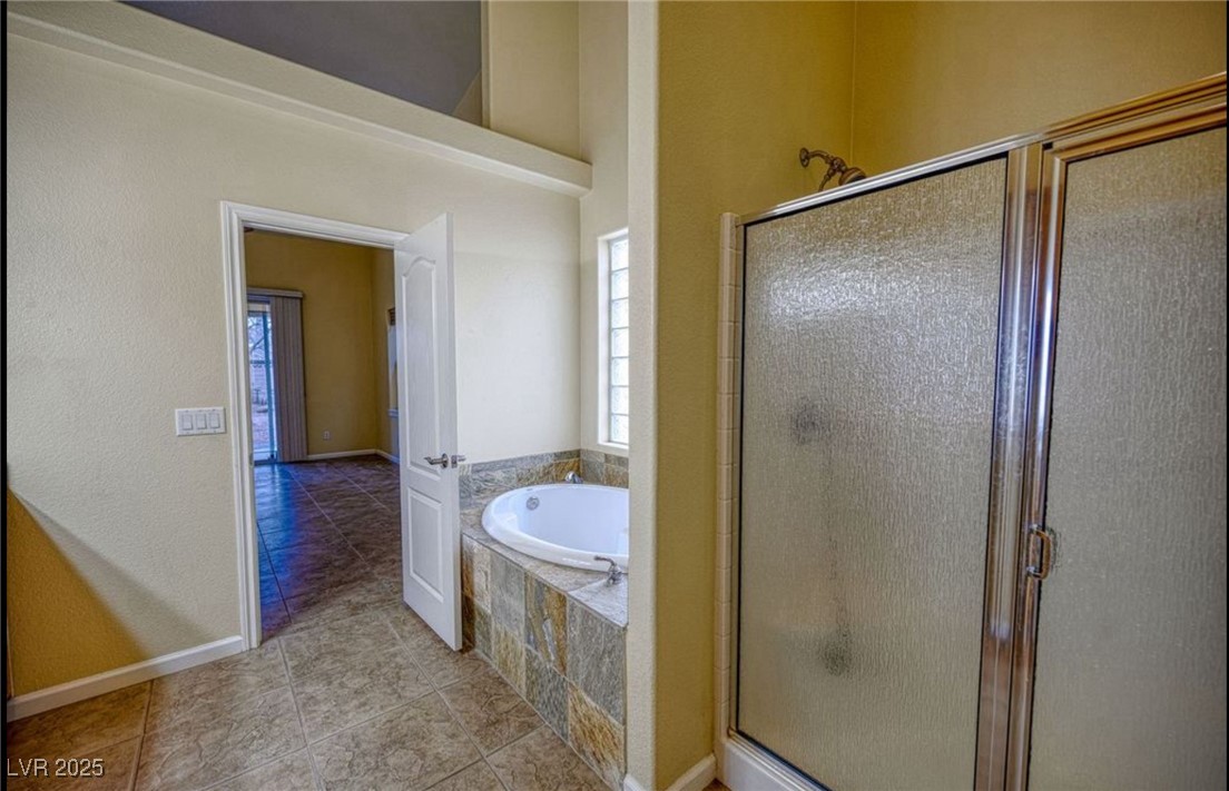 6780 Sandpebble Street Pahrump, NV 89061 - Photo 11 of 25 Bathroom with a stall shower, a garden tub, a textured wall, and light tile patterned floors