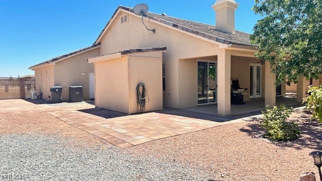 6780 Sandpebble Street Pahrump, NV 89061 - Photo 16 of 25 Rear view of house featuring stucco siding and a chimney