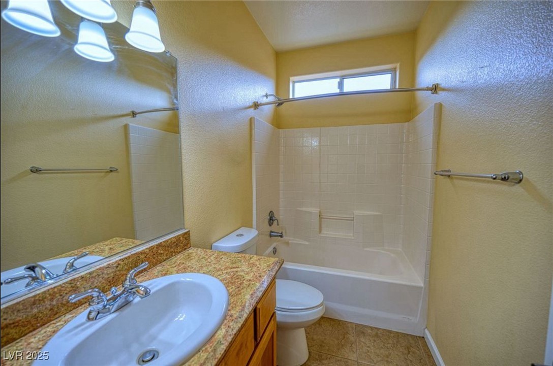 6780 Sandpebble Street Pahrump, NV 89061 - Photo 7 of 25 Full bathroom with a textured wall, bathtub / shower combination, vanity, and light tile patterned floors