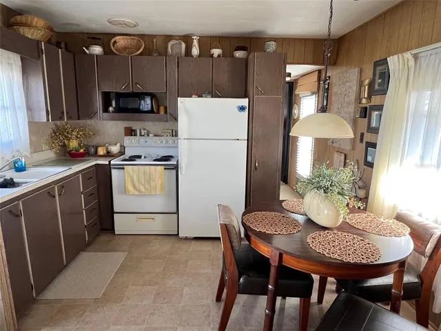 a kitchen with stainless steel appliances a table chairs and a refrigerator