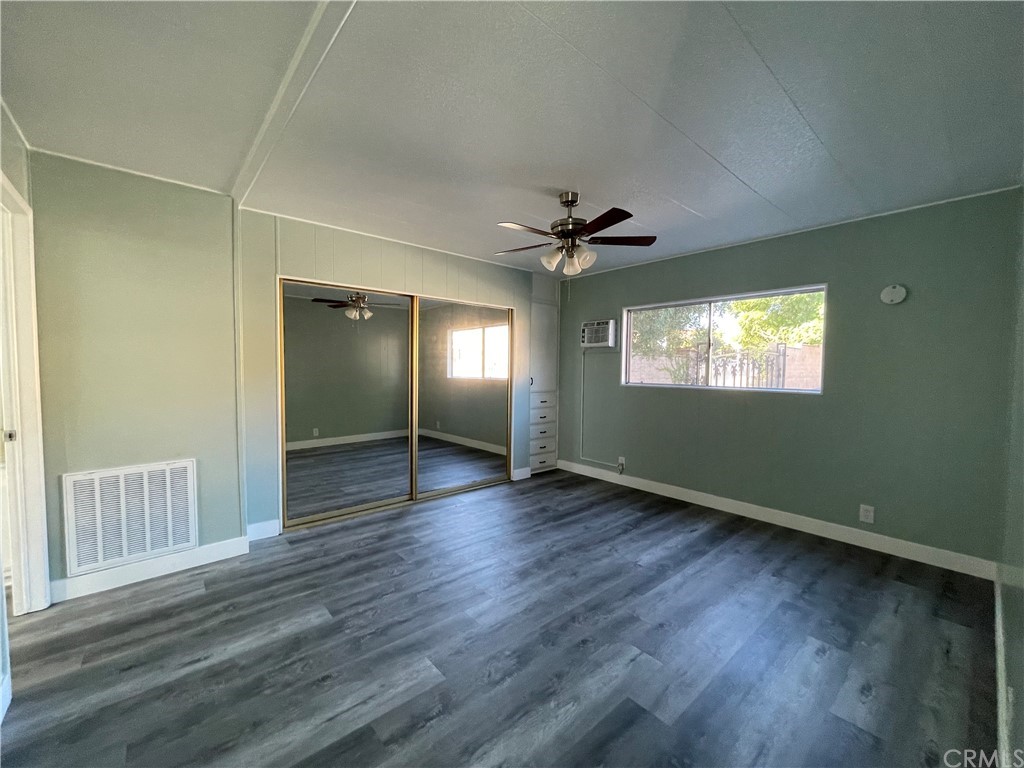 5803 Mission Riverside Ca, Unit 95 Riverside, CA 92509 - Photo 13 of 15 a view of an empty room with wooden floor and a window