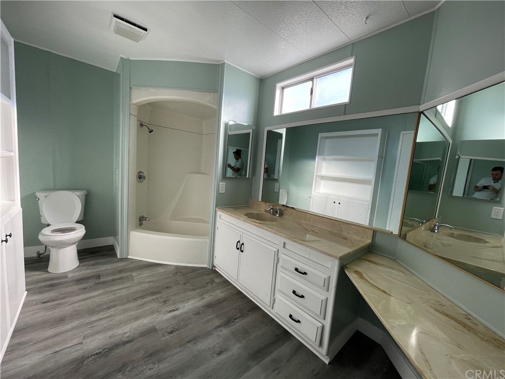 5803 Mission Riverside Ca, Unit 95 Riverside, CA 92509 - Photo 14 of 15 a spacious bathroom with a granite countertop sink a toilet a mirror and a bathtub