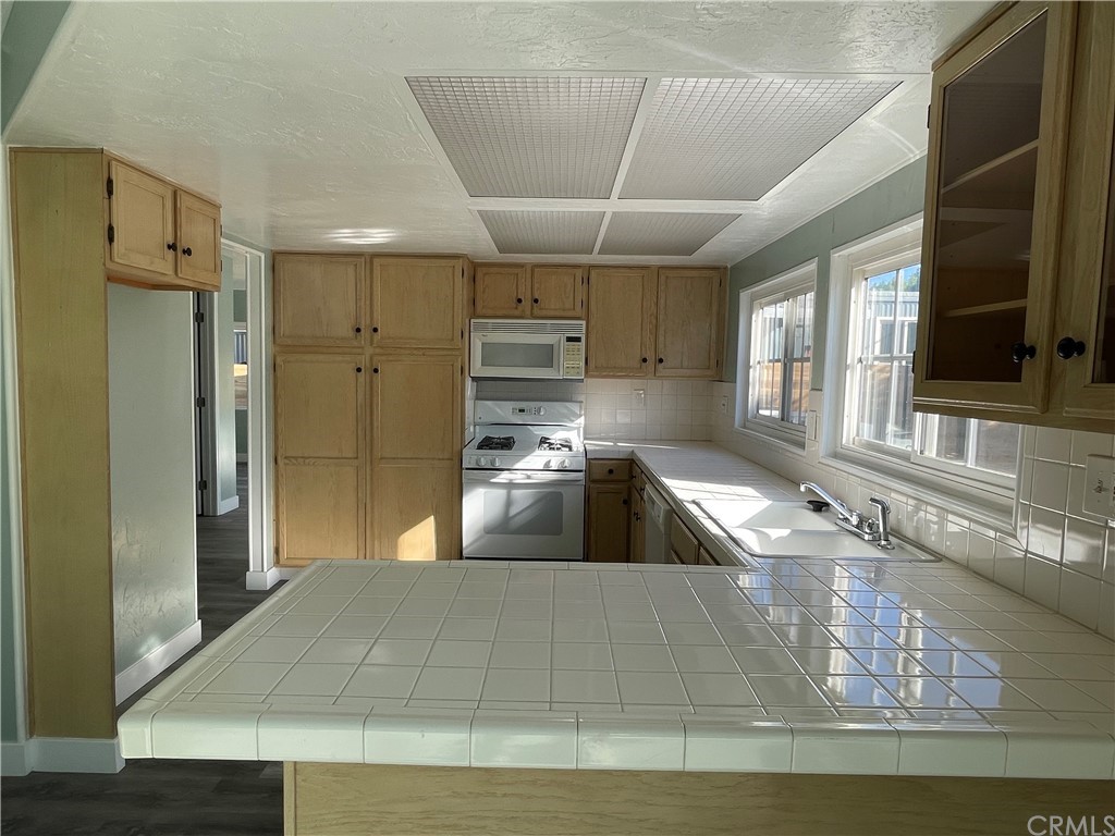 5803 Mission Riverside Ca, Unit 95 Riverside, CA 92509 - Photo 3 of 15 a large kitchen with stainless steel appliances granite countertop a sink window and cabinets