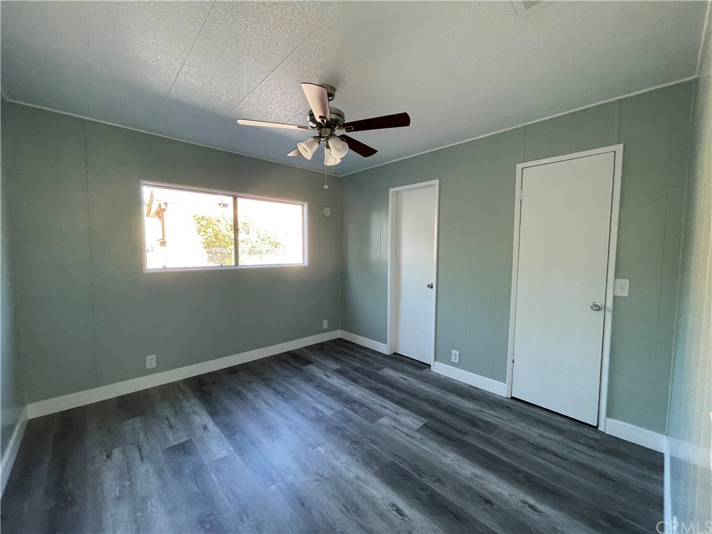 5803 Mission Riverside Ca, Unit 95 Riverside, CA 92509 - Photo 10 of 15 a view of an empty room with wooden floor and a window