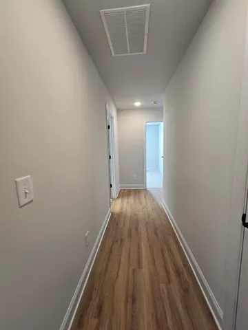 a view of a hallway with wooden floor and staircase