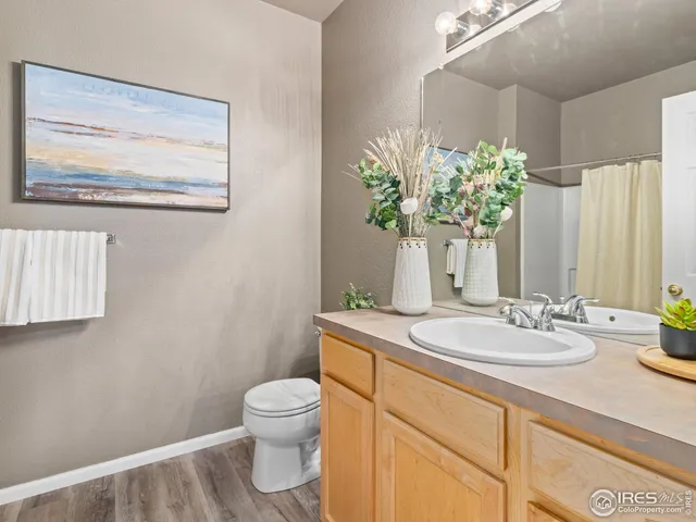 a bathroom with a granite countertop sink a toilet and a mirror