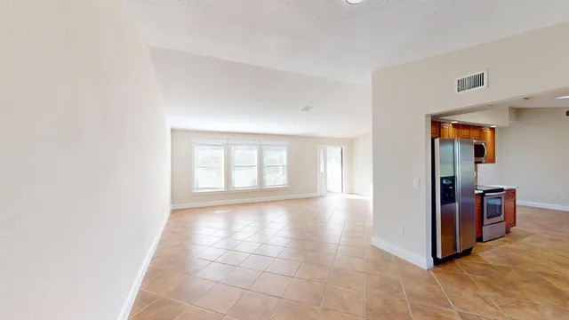 a view of a hallway to kitchen and wooden floor
