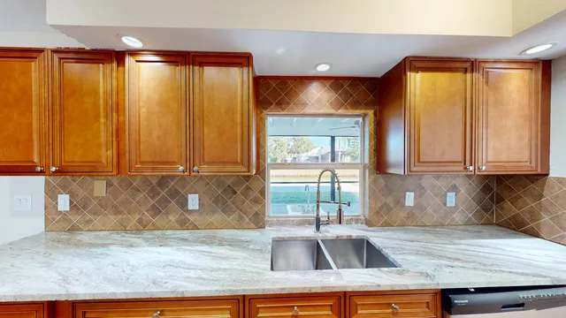 a kitchen with granite countertop a sink and a stove top oven