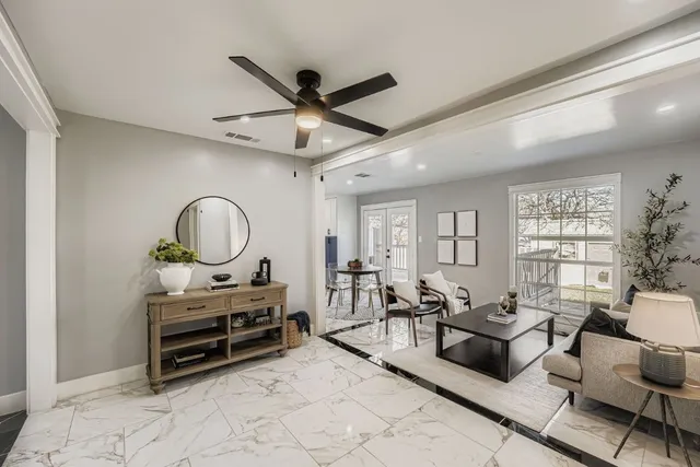 a living room with furniture a window and a ceiling fan