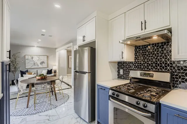 a kitchen with a stove a refrigerator and cabinets