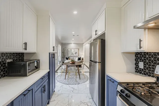a kitchen with stainless steel appliances a stove a sink and a refrigerator
