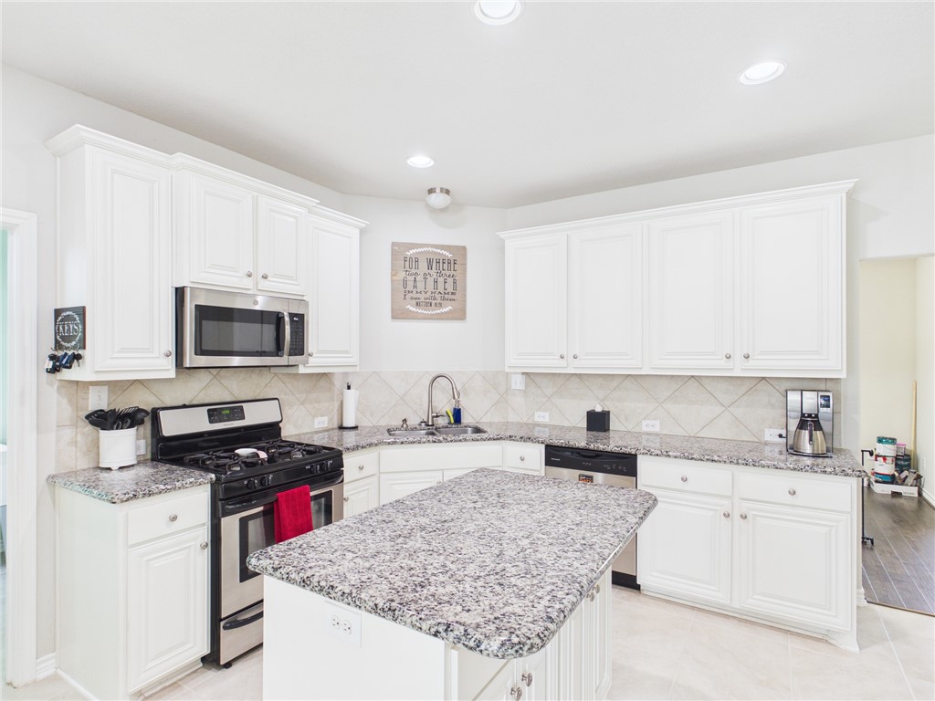10645 C Hoppess Road Franklin, TX 77856 - Photo 11 of 50 a kitchen with stainless steel appliances granite countertop a stove top oven a sink a refrigerator and white cabinets