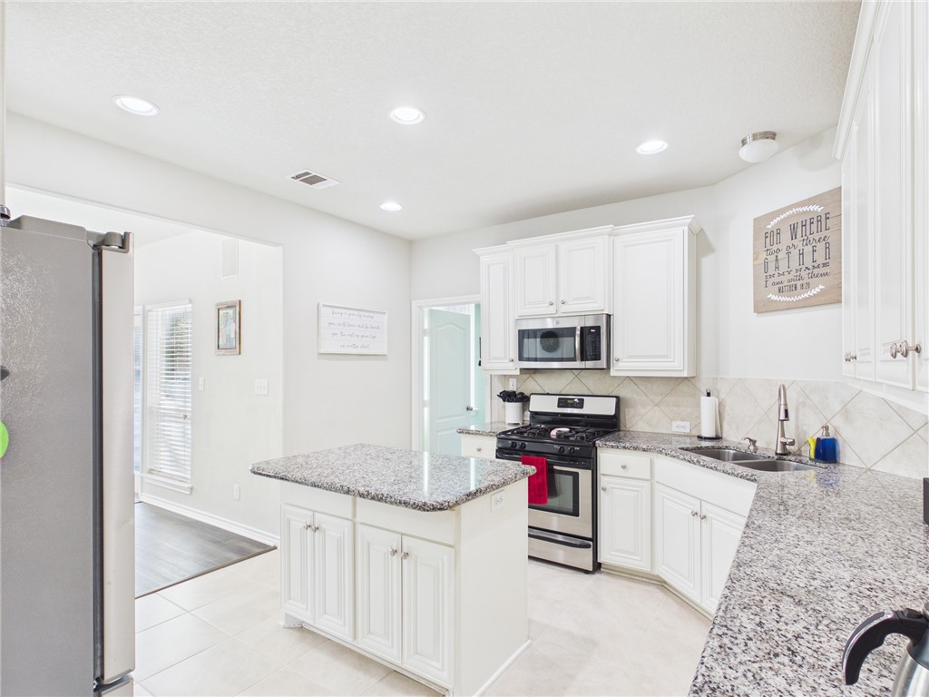 10645 C Hoppess Road Franklin, TX 77856 - Photo 13 of 50 a kitchen with stainless steel appliances granite countertop a stove top oven a sink and dishwasher